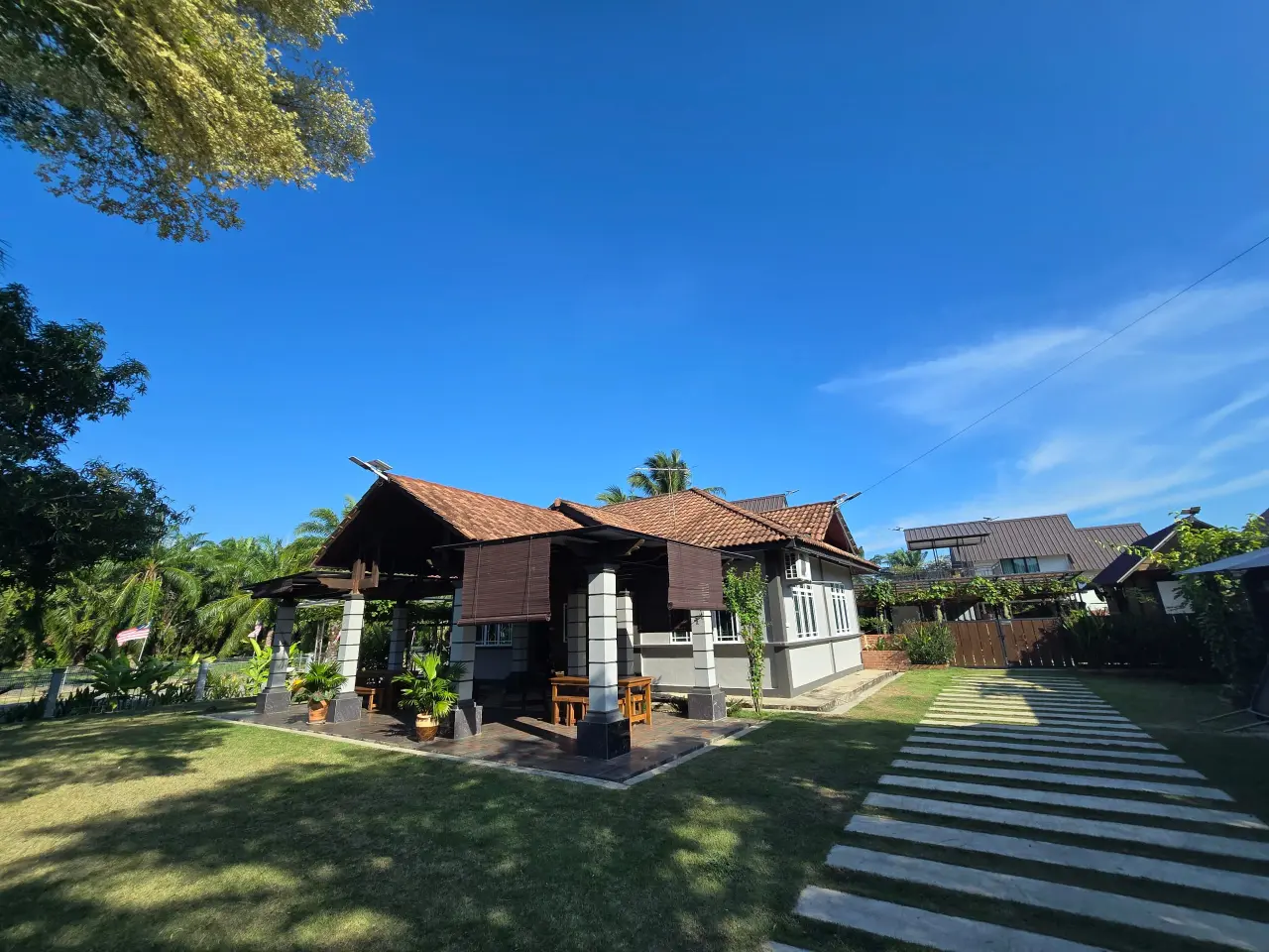 Timber-gabled cottage on a green lawn at Abah Don Cottage, a homestay in Sungai Pelek, Sepang